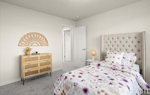 A bedroom with a large bed and a wooden dresser.