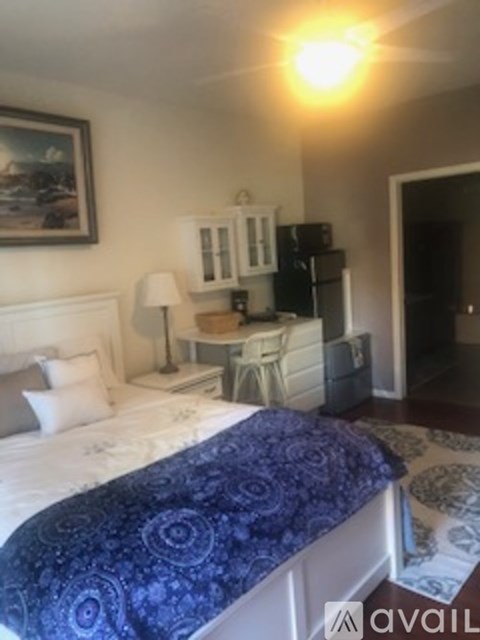 A bedroom with a bed, nightstand, and lamp.