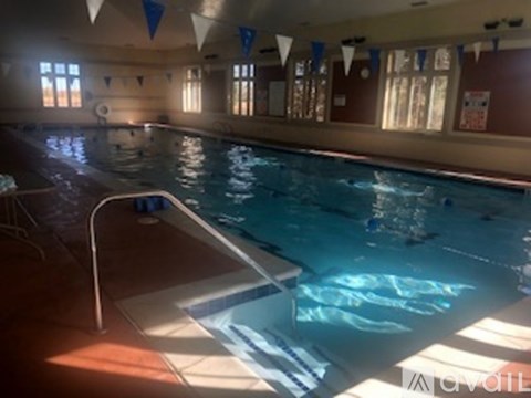 A large indoor swimming pool with a diving board.