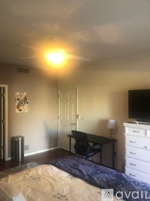 A bedroom with a bed, desk, and chair.