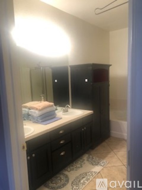 A bathroom with a sink, mirror, and towel.