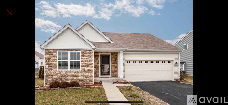 A house with a brown brick exterior and a white garage door.