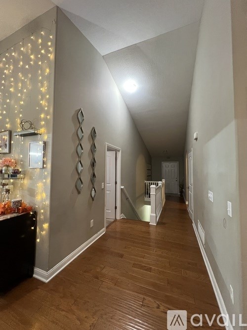 A hallway with a Christmas tree and lights on the wall.