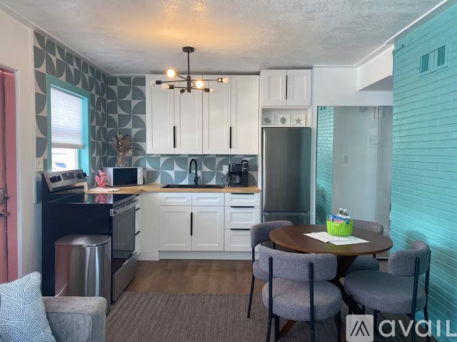 A kitchen with a table and chairs in front of it.
