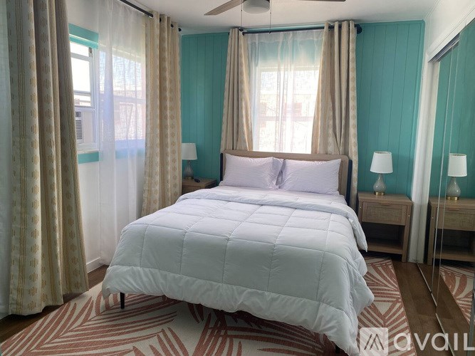 A bedroom with a large bed and a ceiling fan.