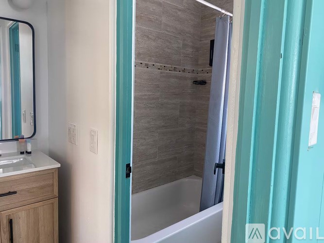 A bathroom with a white sink and a shower with a glass door.