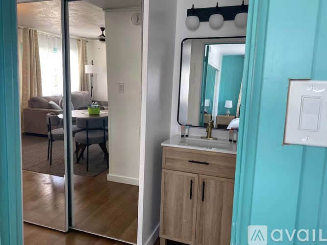 A bathroom with a mirror, sink, and a cabinet.