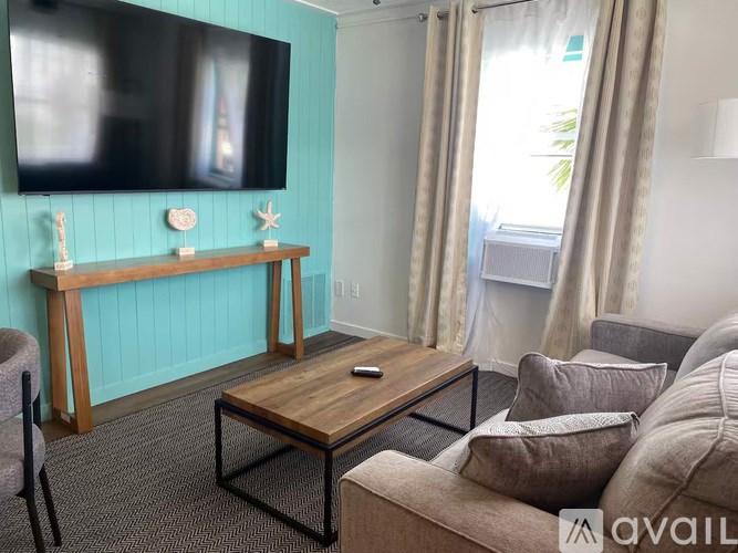 A living room with a couch, a coffee table, and a television.