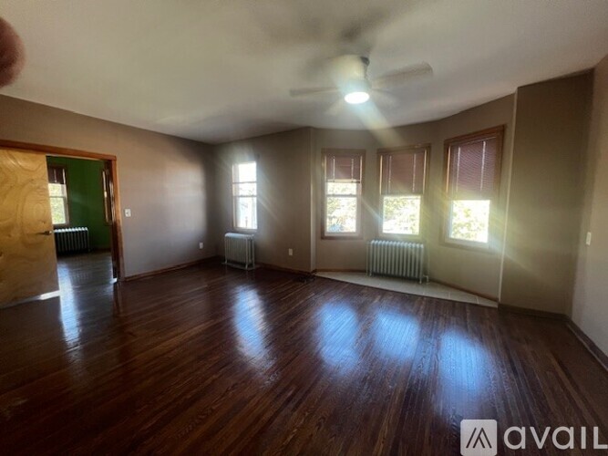 A room with wooden floors and a ceiling fan.