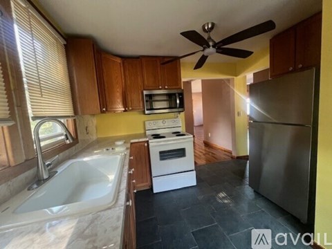 A kitchen with a white sink and a stainless steel refrigerator.
