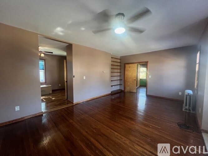 A room with wooden floors and a ceiling fan.