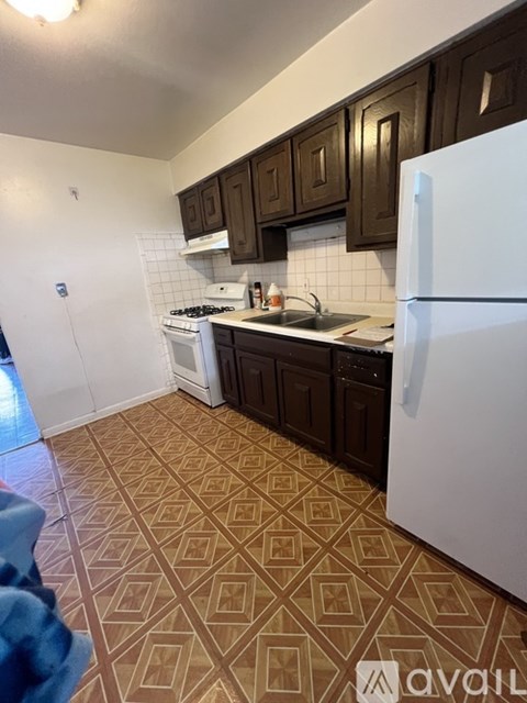 A kitchen with brown cabinets and a white refrigerator.