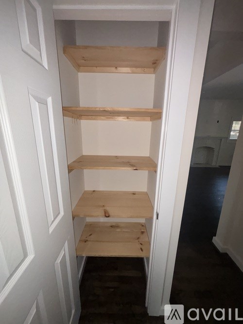 A white door with a shelf under it.