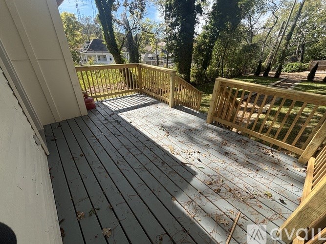 A wooden deck with a railing and a red fire extinguisher.