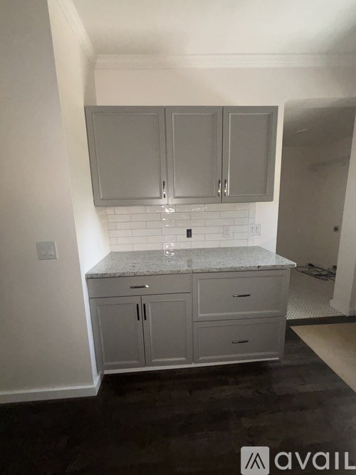 A kitchen with white cabinets and a granite countertop.