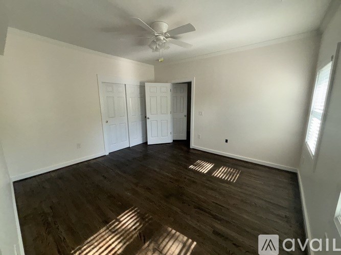 A room with wooden floors and a ceiling fan.