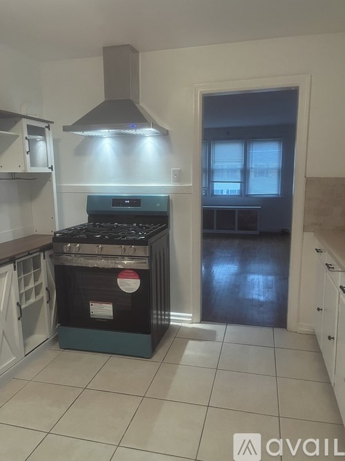 A kitchen with a stove and a hood.