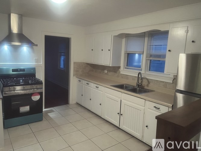 A kitchen with white cabinets and a stainless steel refrigerator.