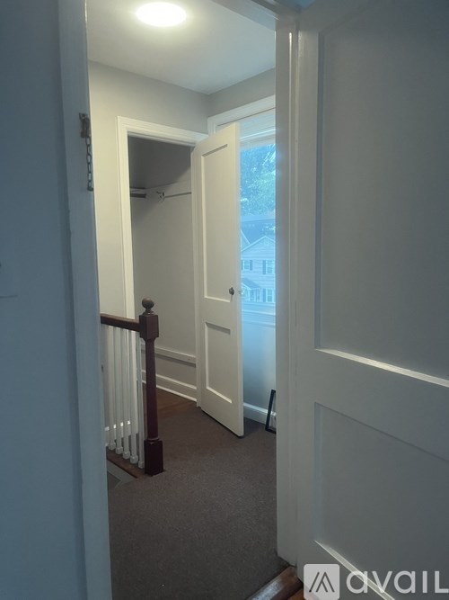 A hallway with a carpeted floor and a white door.