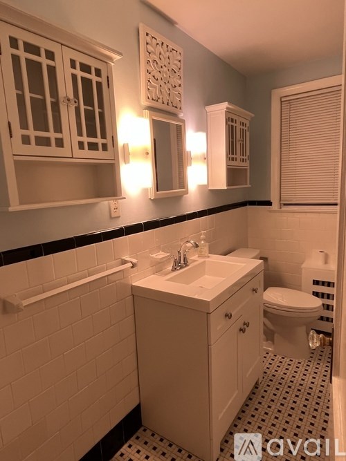 A bathroom with a white sink and toilet.