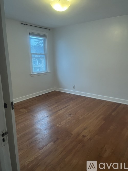A room with wooden flooring and a window.