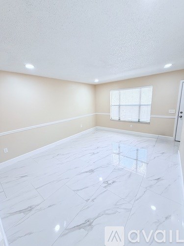 A room with a marble floor and a window with blinds.