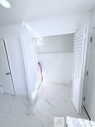 A white room with a door open to a hallway.