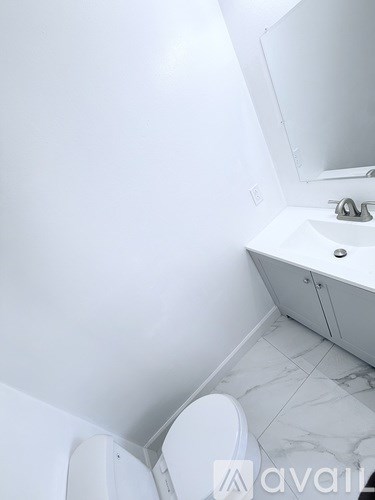 A white toilet sits next to a sink in a small bathroom.