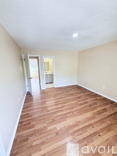 A room with wooden flooring and two doors.