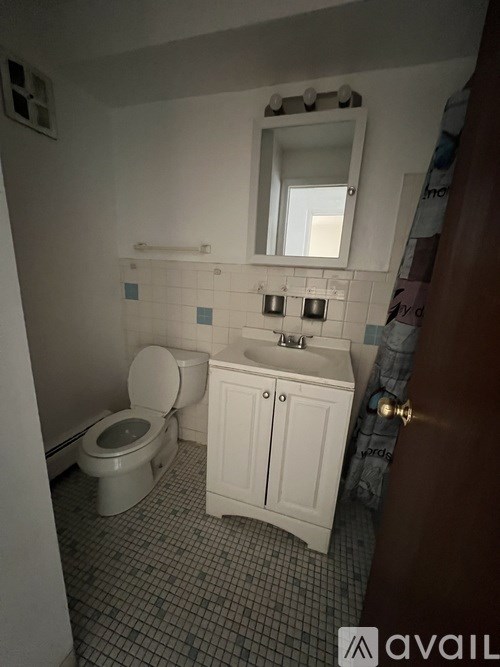 A white toilet and sink in a small bathroom.