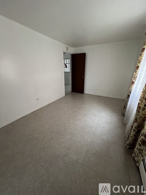 A room with a door and a window with curtains.