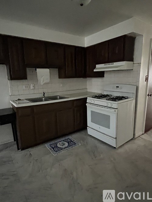 A kitchen with brown cabinets and a white stove top oven.