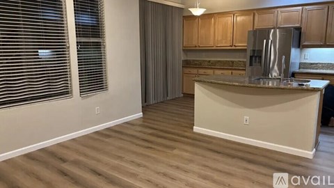 A kitchen with wooden cabinets and a stainless steel refrigerator.
