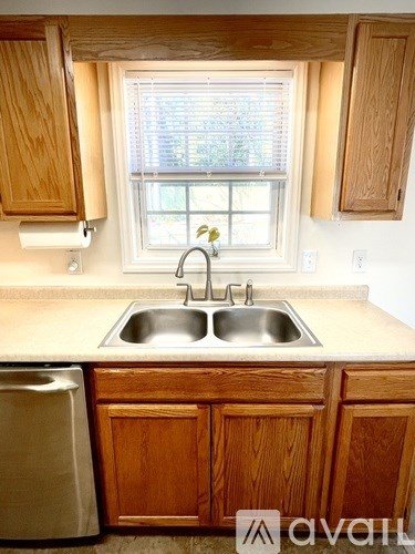 A kitchen with wooden cabinets and a window.