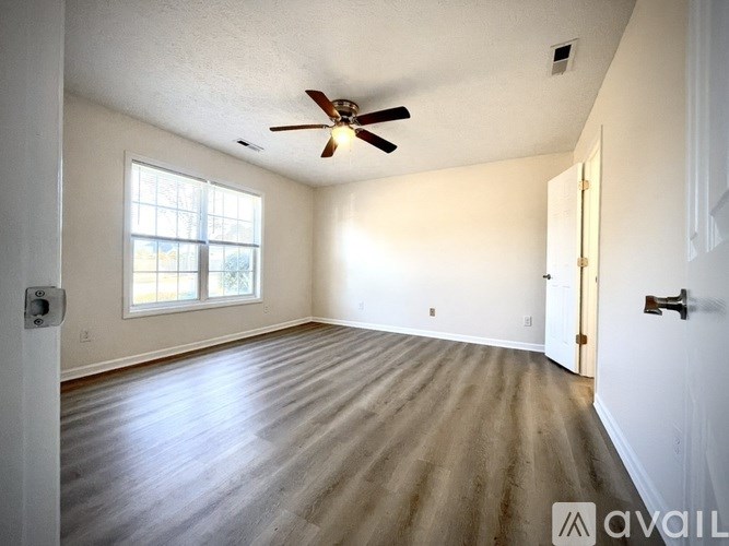A room with a ceiling fan and a window.