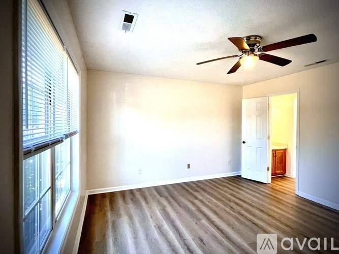 A room with a ceiling fan and wooden flooring.