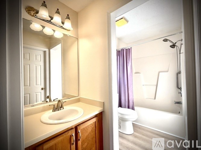 A bathroom with a sink, mirror, and bathtub.