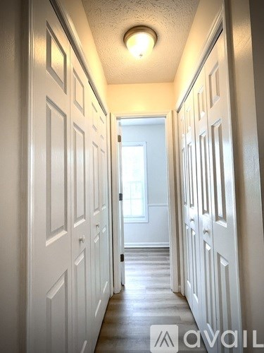 A hallway with white doors and a light on the ceiling.