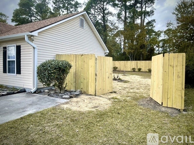 A house with a wooden fence in front of it.