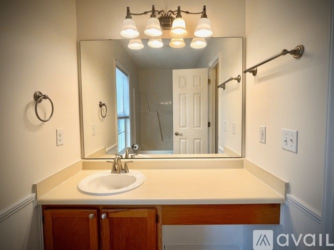 A bathroom with a sink, mirror, and lights.