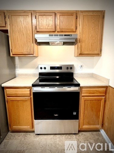 A kitchen with wooden cabinets and a black stove top oven.