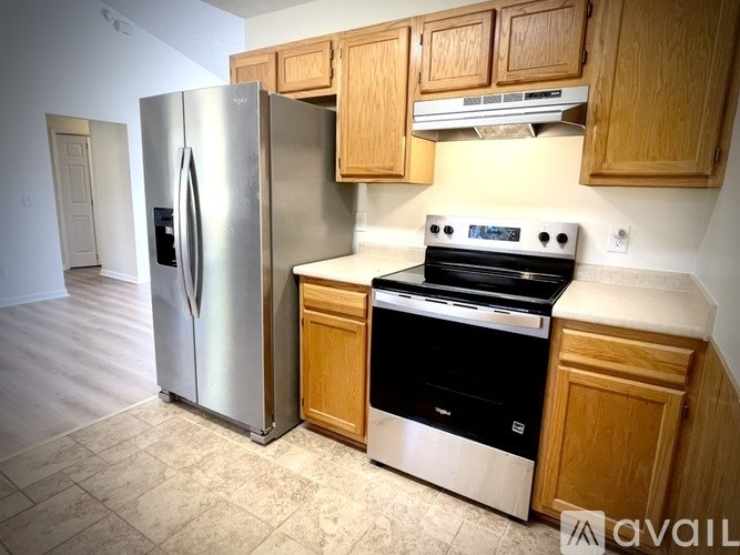 A kitchen with a stainless steel refrigerator and black oven.