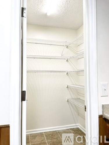 Empty white walk in closet with shelves.