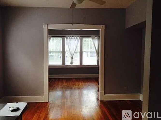 A room with a window and wooden floors.