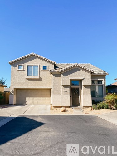 A house with a garage and a driveway in front of it.