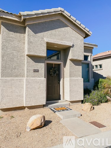 A house with a brown door and a small garden in front.