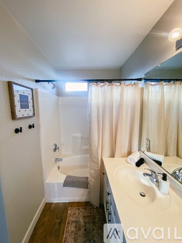 A bathroom with a white sink and a shower with a white curtain.