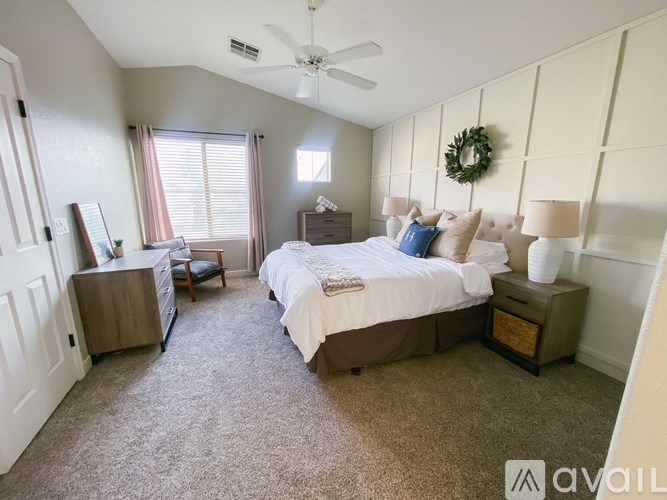 A bedroom with a large bed and a ceiling fan.
