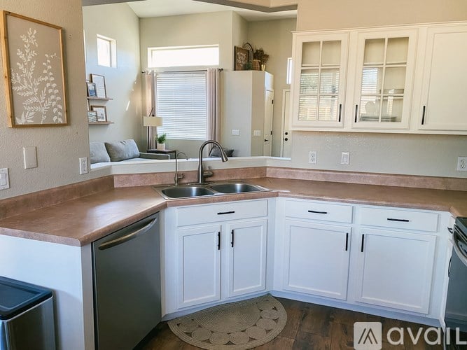 A kitchen with white cabinets and a wooden counter top.