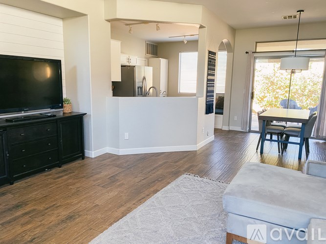 A living room with a television, a couch, and a rug.